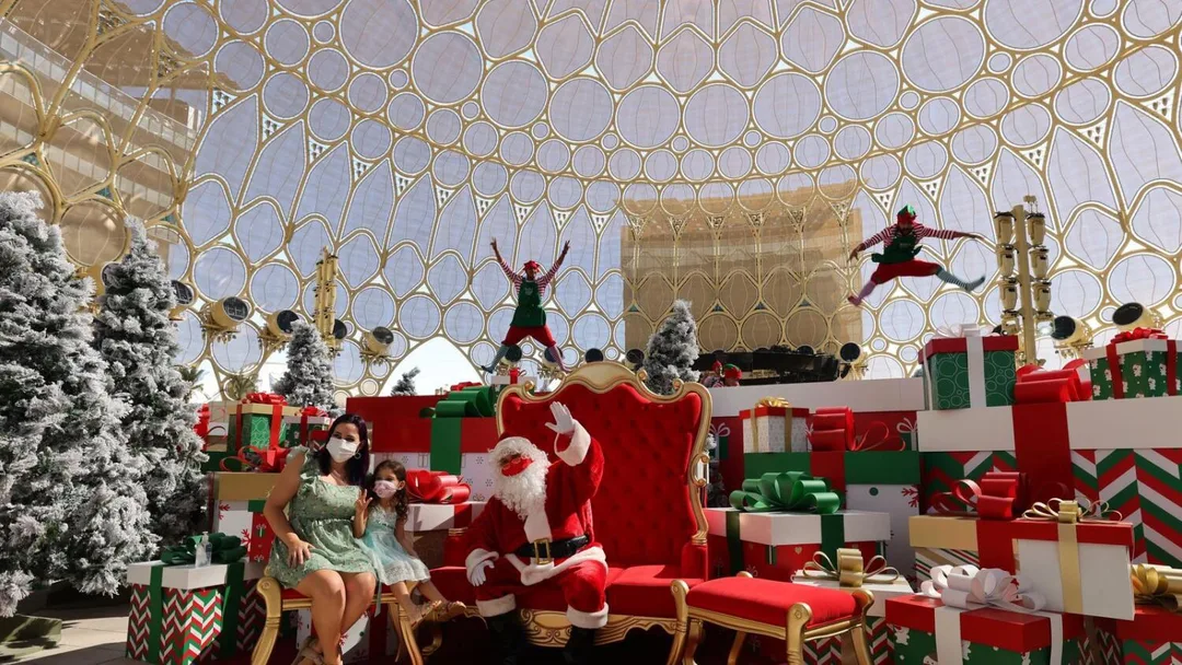 Santa Claus photo experience at Expo 2020 Dubai with festive scenic design, Christmas trees, oversized gift boxes and live performers