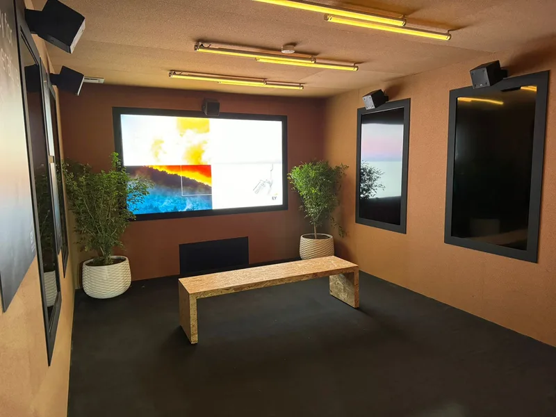 Immersive EY COP28 presentation room with large digital screen, enclosed visitor space and sustainable interior finishes