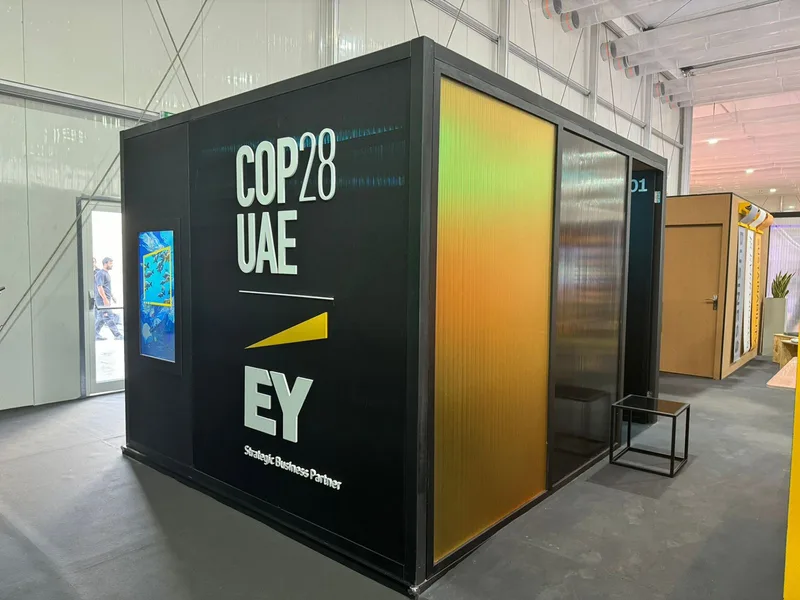 EY modular exhibition pod at COP28 Dubai with recyclable materials, branded graphics and enclosed visitor space