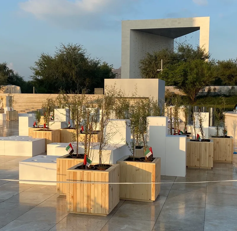 Founder’s Memorial National Day activation with ghaf tree planters, white scenic structures and landscaped public space