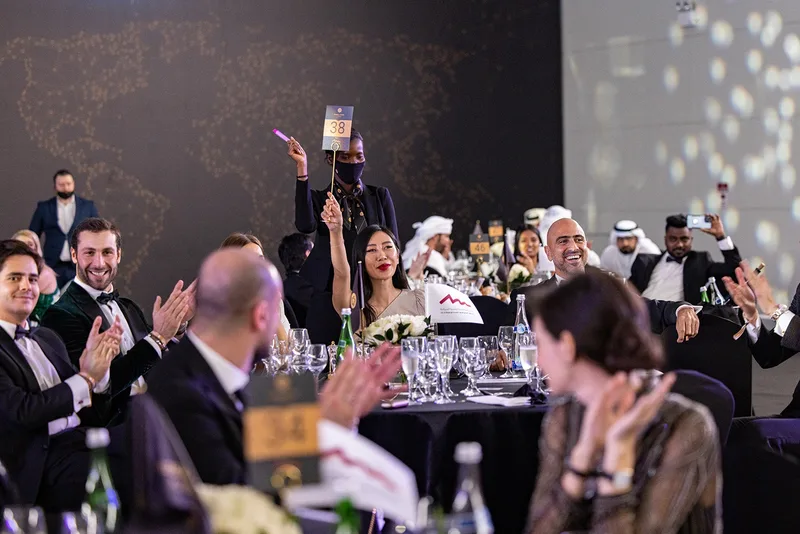 Global Citizen Forum gala dinner with guests taking part in a live fundraising or auction moment