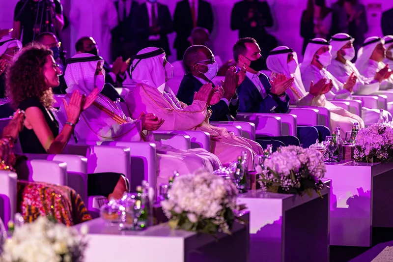 Global Citizen Forum delegates seated in a VIP conference setting with premium hospitality and stage lighting