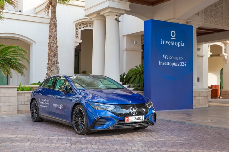 Investopia welcome entrance with branded electric vehicle and freestanding event signage