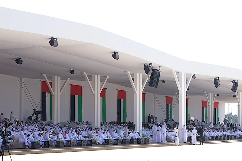 Large official ceremony in Abu Dhabi with seated guests, UAE flags, temporary structures and event production
