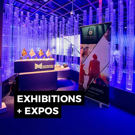 Immersive exhibition stand with illuminated scenic structure, digital display and branded event environment