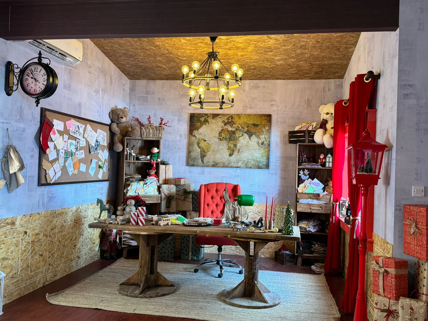Santa’s sustainable workshop with wooden desk, world map, handmade toys, letters and Christmas decorations
