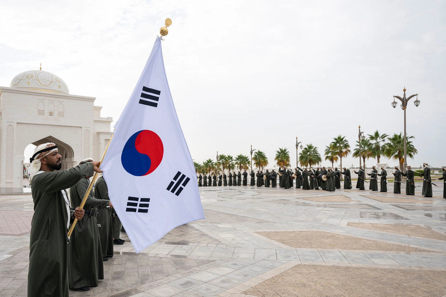 Republic of Korea flag displayed during an official state visit ceremony in Abu Dhabi with Emirati ceremonial performers