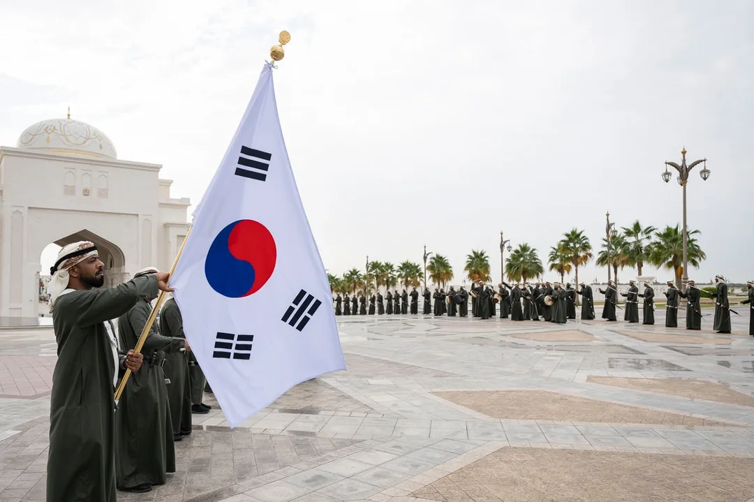 Republic of Korea flag displayed during an official state visit ceremony in Abu Dhabi with Emirati ceremonial performers