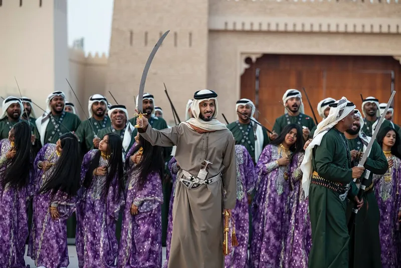 Emirati cultural performers at Union Parade 2025 in traditional dress with ceremonial sticks and group performance