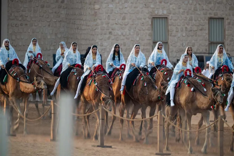 Camel procession at Union Parade 2025 in Abu Dhabi with traditionally dressed riders and cultural performers