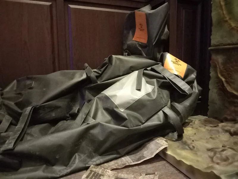 Dark bagged-body props used as unsettling decorative elements within the themed installation
