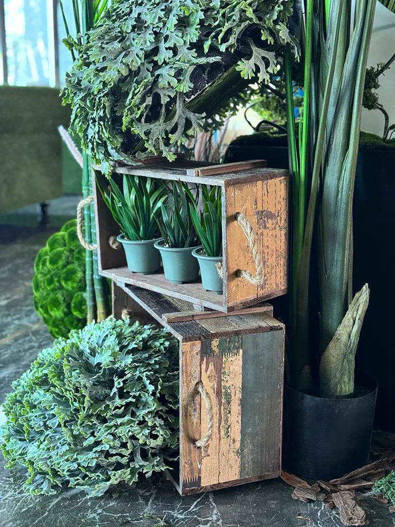 Layered fantasy styling combining oversized greenery, textured moss, bark and decorative stone props.