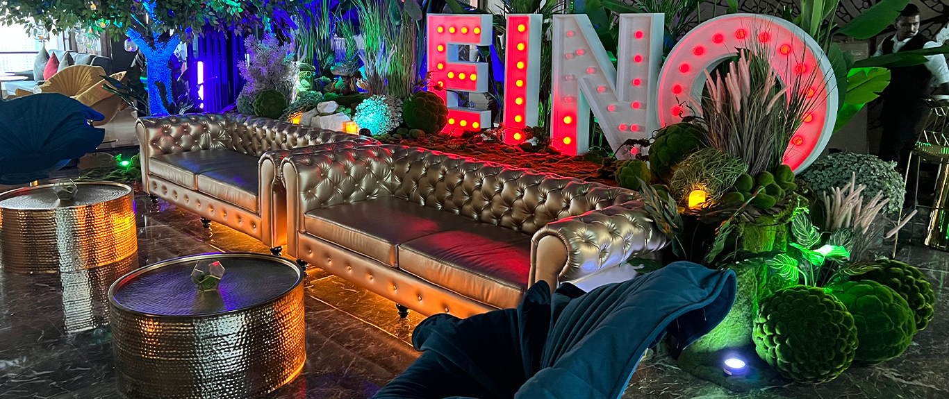 Evolution Prop Shop enchanted forest styling with illuminated EINO letters and layered greenery in Dubai.