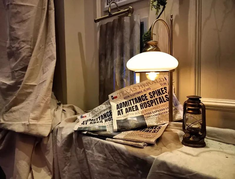 Aged kerosene lanterns and distressed newspaper props creating detailed post-apocalyptic decorative styling