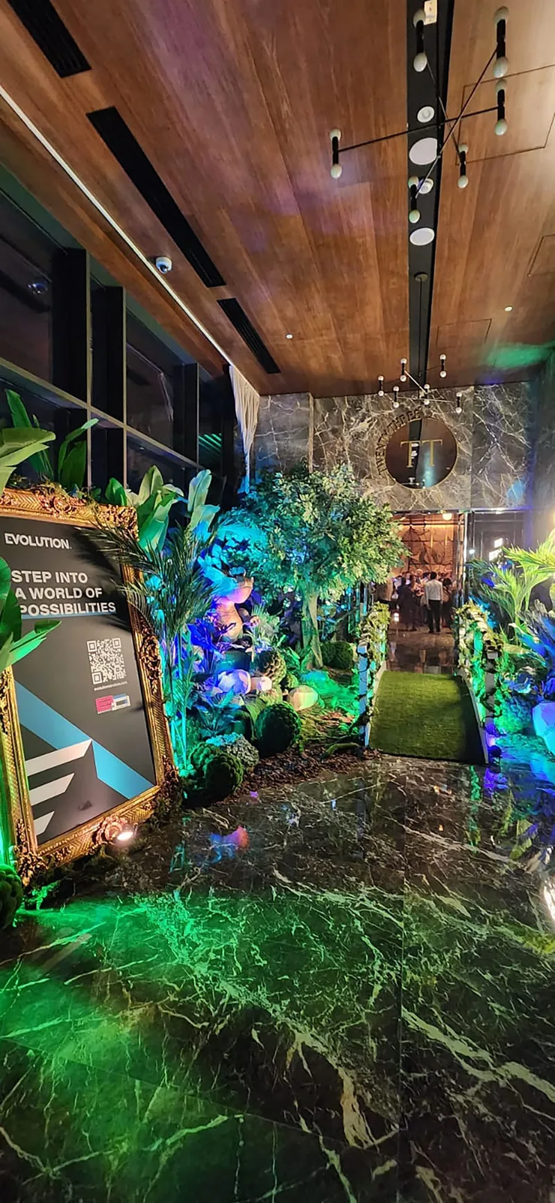 Enchanted woodland feature display combining dragon prop, artificial planting and sculptural green moss forms.