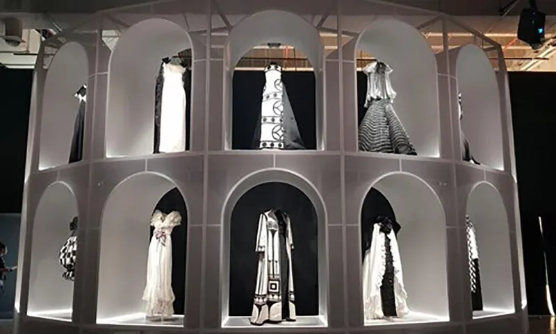 Illuminated monochrome display structure presenting Valentino garments within the M7 Doha exhibition.