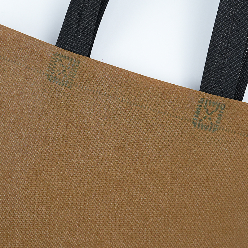 brown non-woven eco-friendly tote bag with black fabric handles and reinforced X-stitching