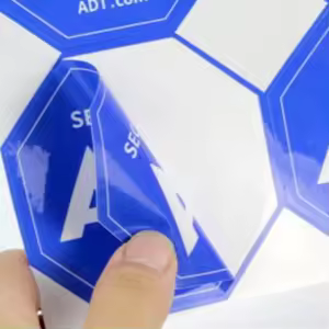 Double sided transparent bottle label with front branding and back print information visible through the clear container.