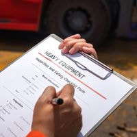 Compliance manager reviewing oil and gas audit documentation, quality records, corrective actions, and regulatory compliance standards.