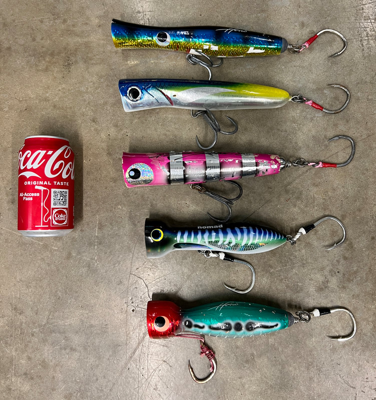 Poppers for GTs from top to bottom - Heru Skipjack, Jackfin Kronos, Blaze Saththa, Nomad Chug Norris, Heru Cubera      Note: These are big lures; that is a standard size soda can.