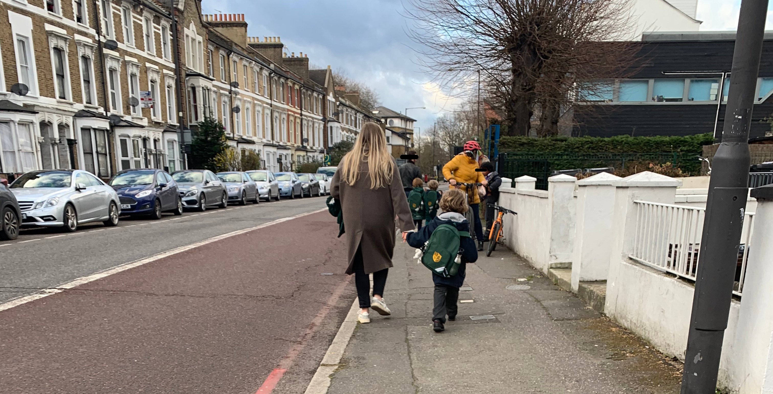 Children with parents and family with bikes on narrow pavement near Linden Children's Centre