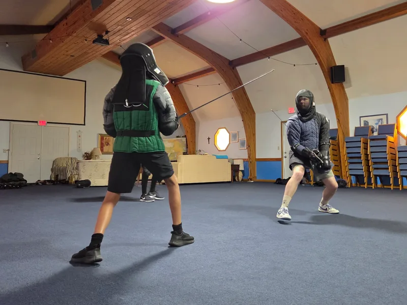 Adult student Malachi and teen student Jacob face off in a longsword duel.
