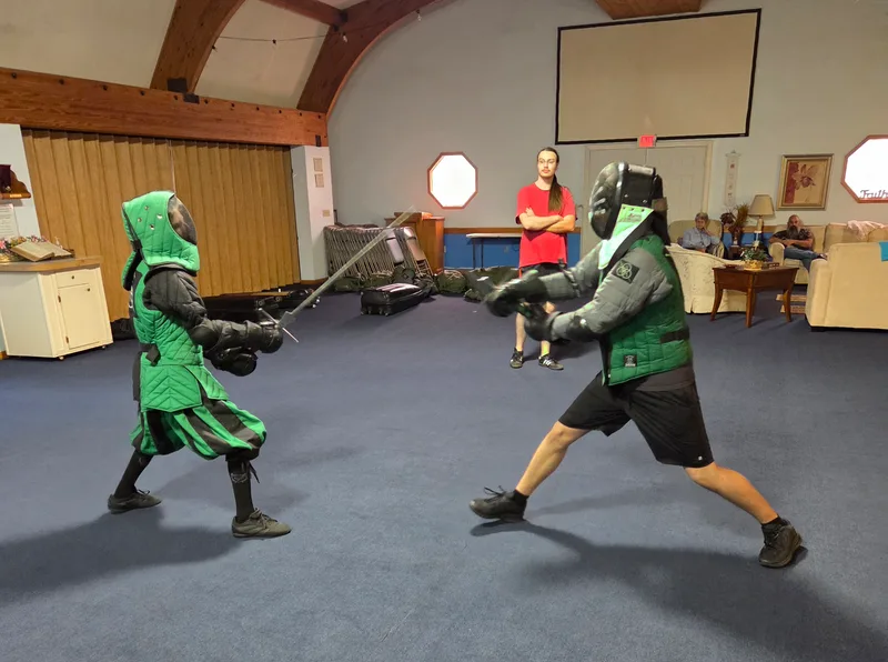Teen students Asher and Theo engaged in a longsword fight.