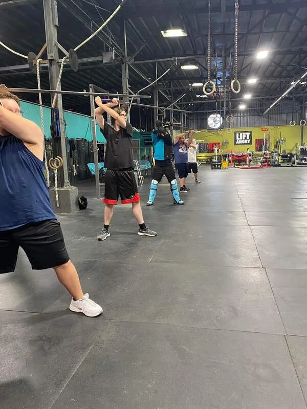 Adult students running through sword stances at the beginning of class.