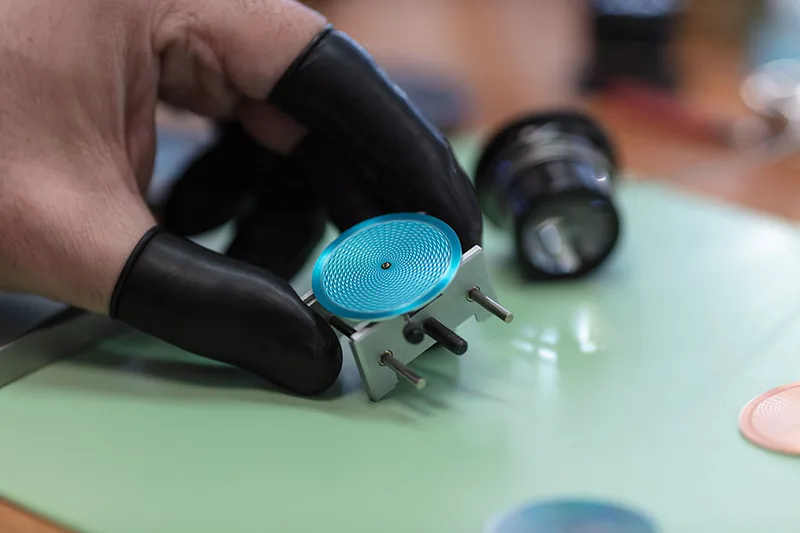 Cadran de montre manipulé avec des gants dans un atelier horloger