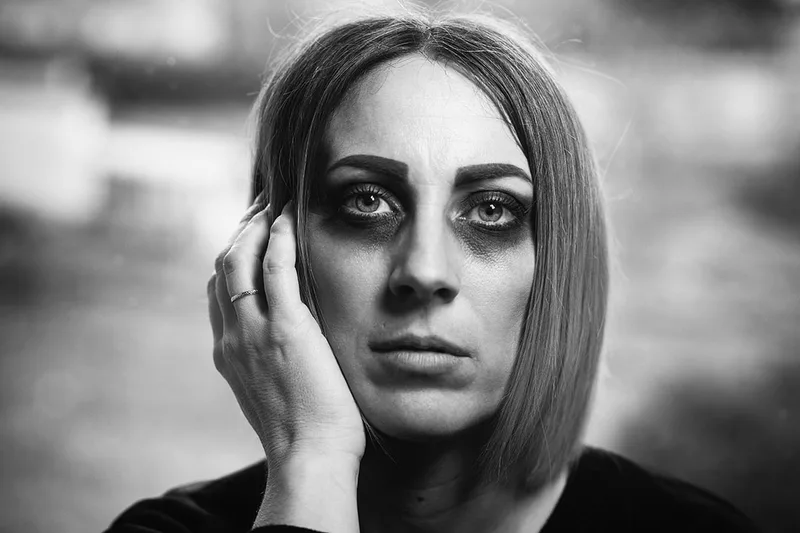 Portrait mélancolique d'une femme au maquillage sombre et à l'ambiance artistique obscure