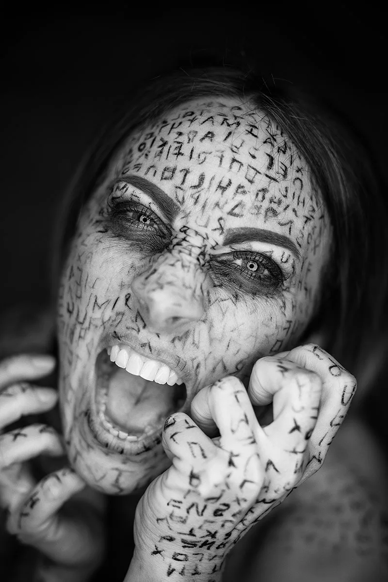 Portrait dramatique en noir et blanc d'une femme au maquillage de runes capturée en plein cri