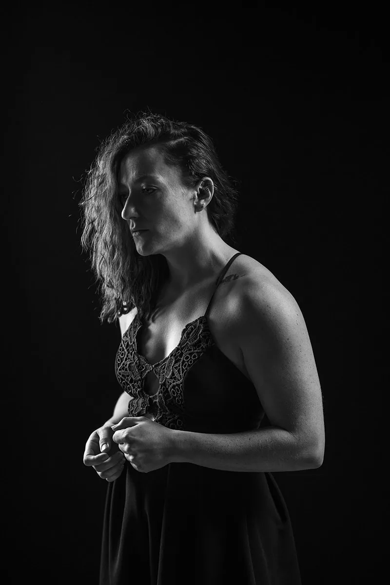 Portrait en robe d'une femme sombre et pensive incarnant le repli et la force intérieure