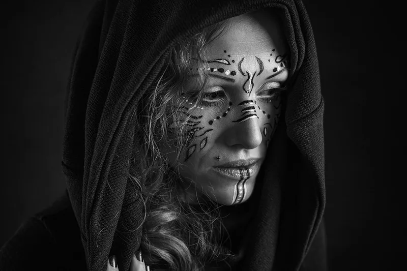 Portrait en noir et blanc d'une femme guerrière au maquillage graphique transmettant de la force