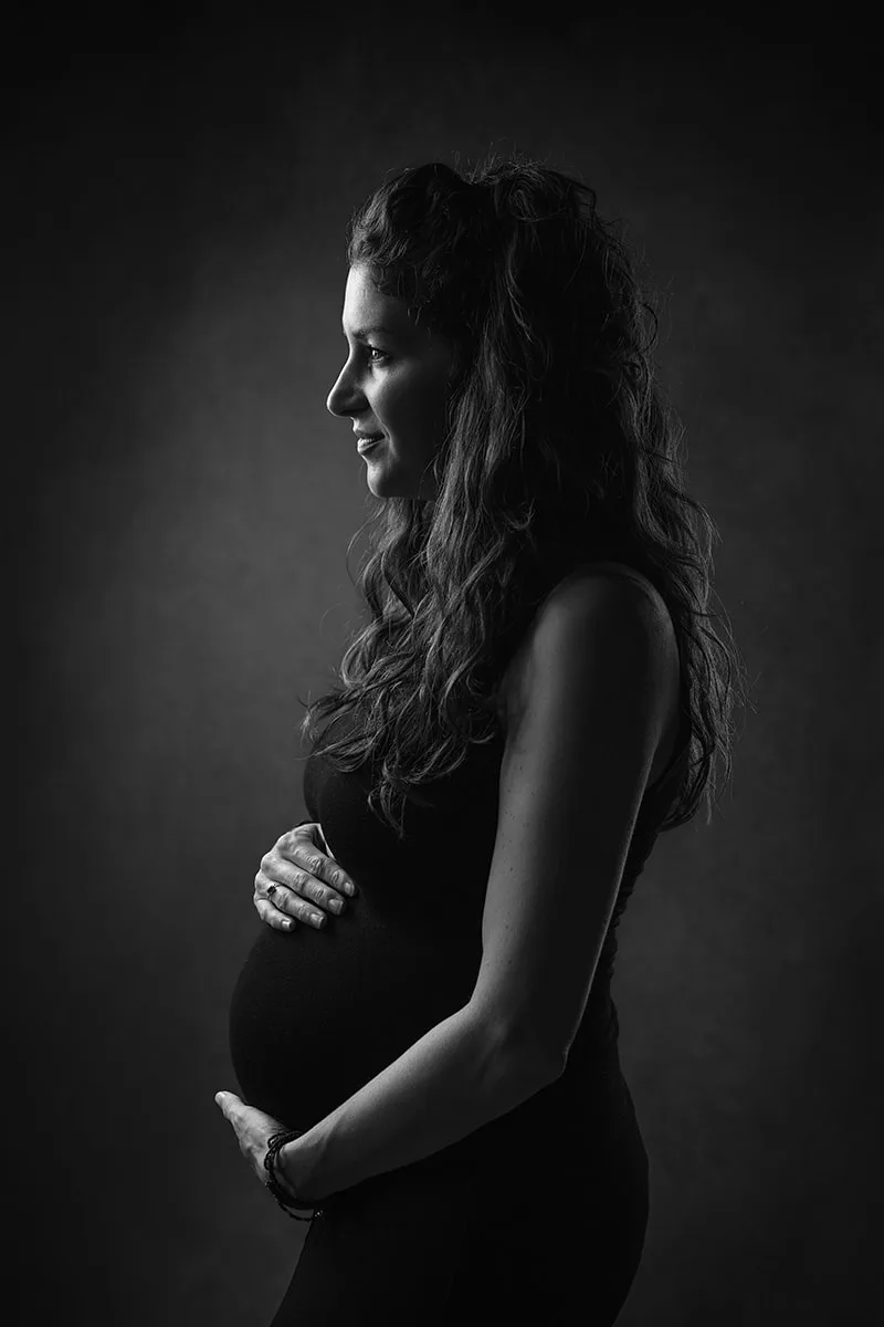 Portrait artistique de maternité mettant en valeur la grossesse d'une maman sous les flashs de studio
