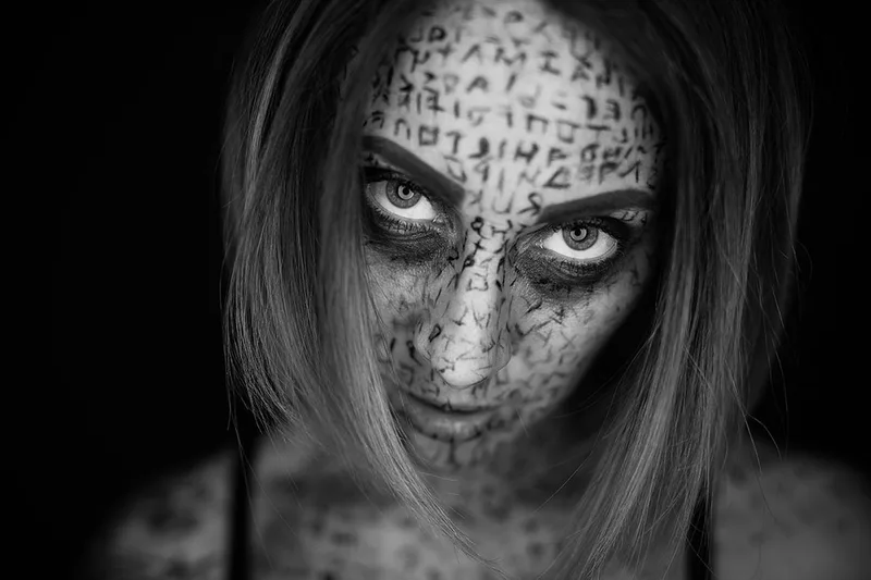Portrait dark art en noir et blanc axé sur la folie et le maquillage runique d'un modèle