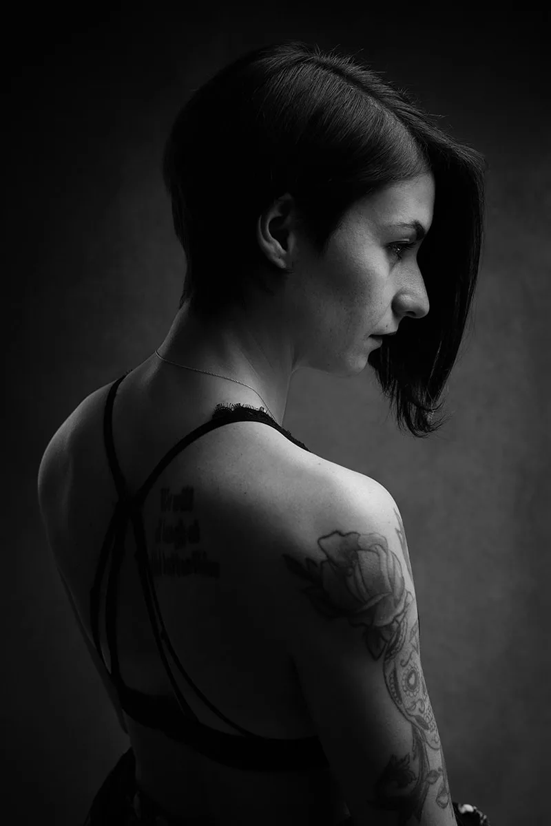 Portrait noir et blanc artistique célébrant la sensualité et les lignes d'un corps tatoué