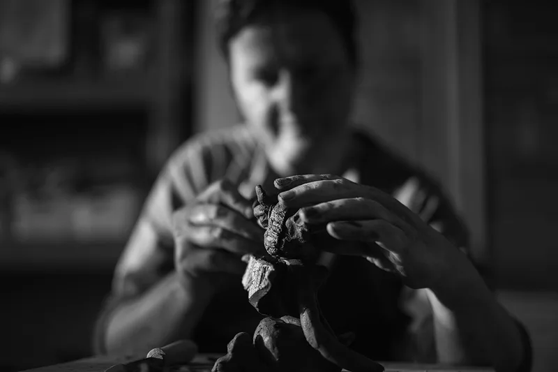 Artisane sculptrice façonnant une œuvre à la main dans son atelier, photographie de savoir-faire à Metz