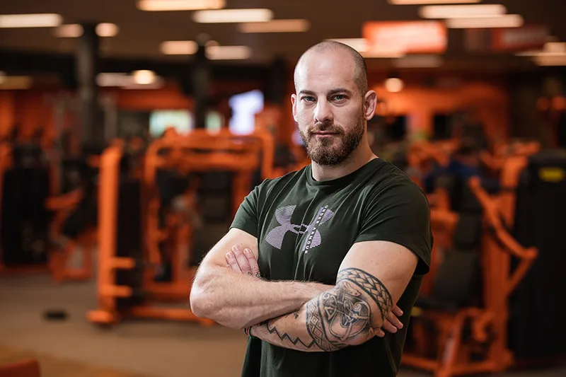 Portrait d'un coach sportif prenant une pose avec les bras croisés