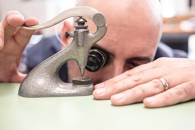 Artisan réalisant un travail de précision sur une pièce horlogère