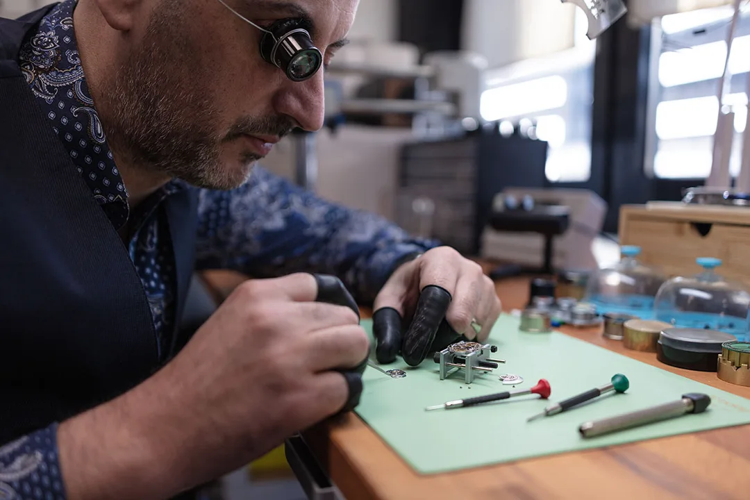 Horloger travaillant sur une montre Sartory-Billard avec des outils de précision