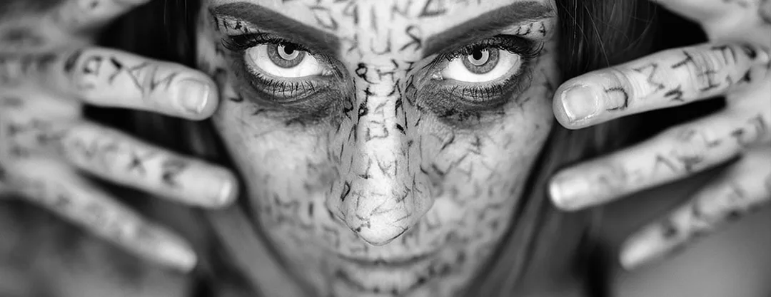Portrait d'art en noir et blanc d'une femme au maquillage runique et regard d'une grande intensité