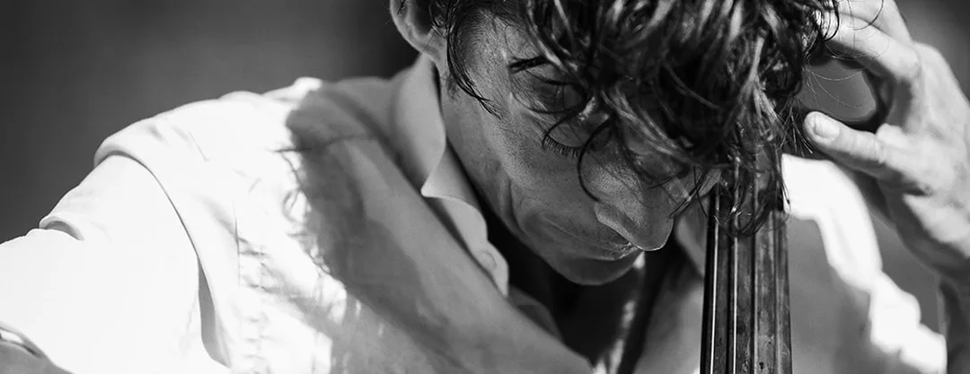 Photographie de rue humaniste en noir et blanc d'un musicien jouant du violon