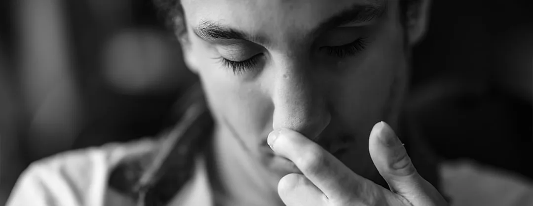 Portrait documentaire en noir et blanc d'un résident en Maison d'Accueil Spécialisée (MAS), capturant un moment de repli et de réflexion