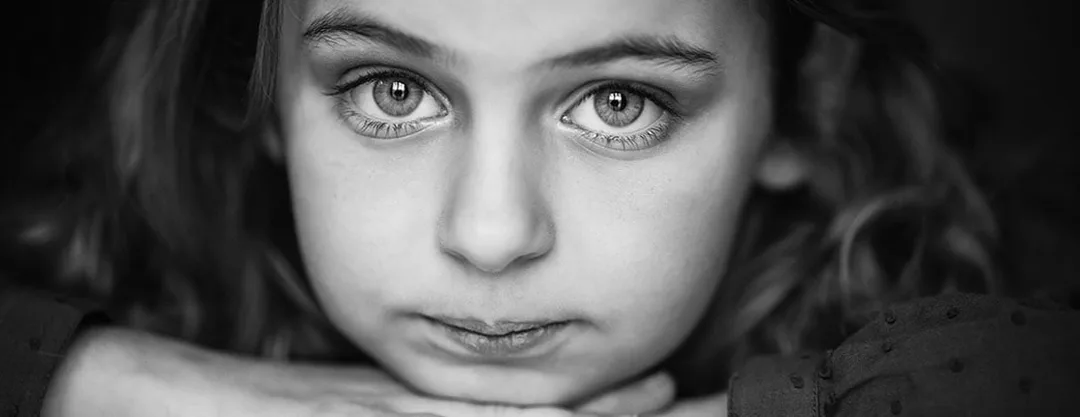 Portrait artistique en noir et blanc d'un enfant au regard intense et lumineux