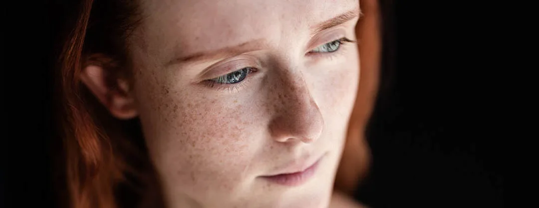 Portrait artistique en couleur d'une femme rousse au regard et aux yeux bleus lumineux