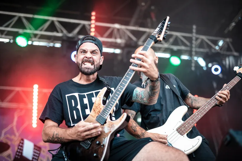 Le guitariste d'Eight Sins faisant une grimace amusée face au public pendant son set