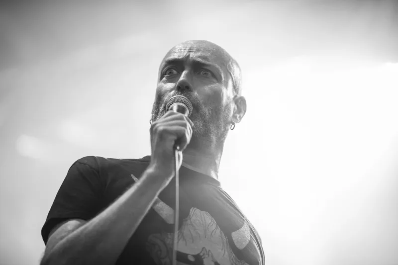 Reuno, chanteur de Lofofora, adoptant une attitude scénique théâtrale en noir et blanc