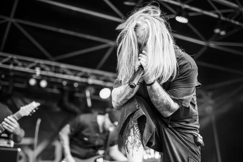 Le chanteur de Syderal, cheveux au vent, donnant tout son souffle sur scène en noir et blanc