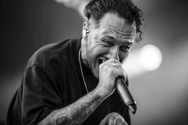 Cliché en noir et blanc du chanteur de Resolve évacuant l'énergie de son morceau par un cri intense