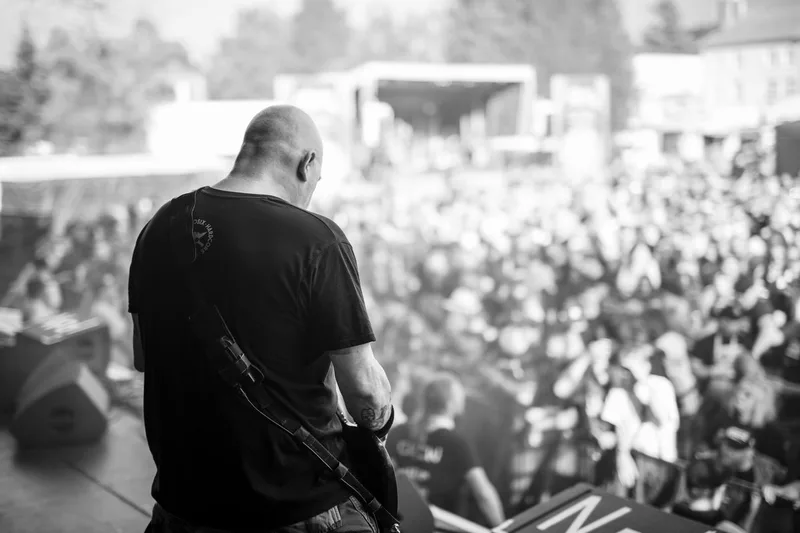 Le guitariste de Pro-Pain face à une foule en délire lors d'un concert capturé en noir et blanc